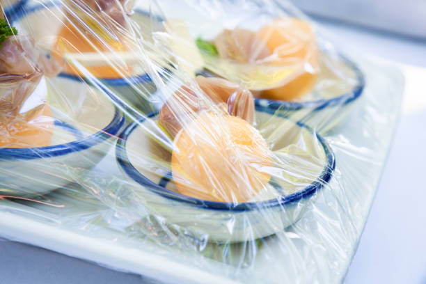 Midsection of male vendor holding peaches in box. Close-up of man is selling fruits. He is standing against market stall.