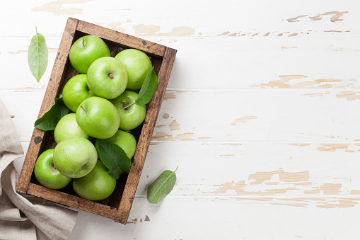 Ripe green apples in wooden box. Top view with space for your text