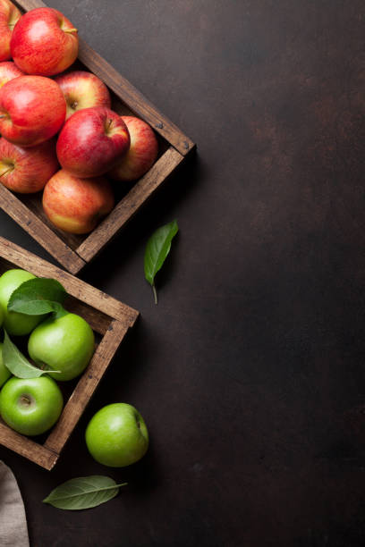 istock Green and red apples in wooden box 974595452