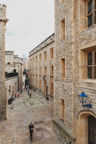 old buildings and towers in the inner ward area of royal palace and fortress of the tower of london, a historic castle and popular tourist attraction located on the north bank of the river thames in central london, england - built structure church flint stone imagens e fotografias de stock