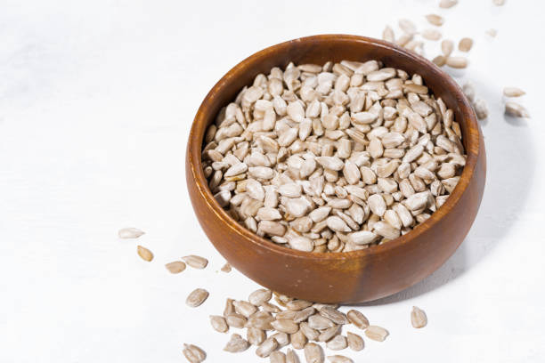 istock bowl with sunflower seeds on white background 974602600