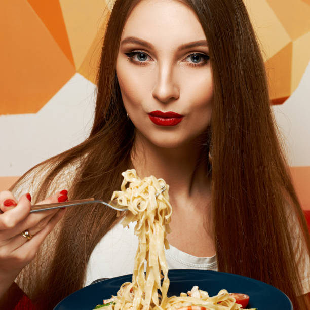 istock Attractive woman eating seafood pasta 974614426
