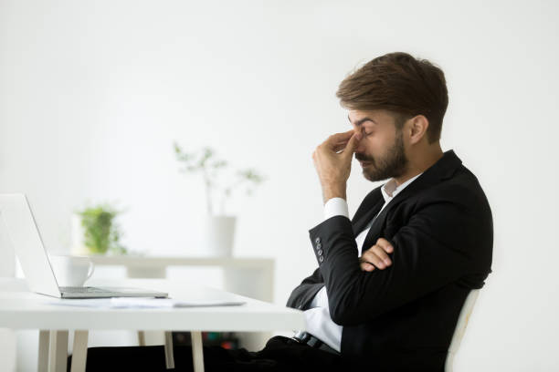 istock Exhausted businessman feeling tired massaging nose bridge 974617722