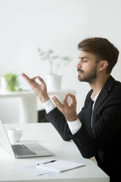 spokojny biznesmen relaksujący i medytujący w miejscu pracy w biurze - spirituality yoga zen like meditating zdjęcia i obrazy z banku zdjęć