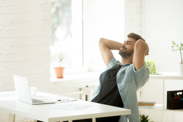 istock Smiling relaxed worker leaning back in chair during work break 974617750