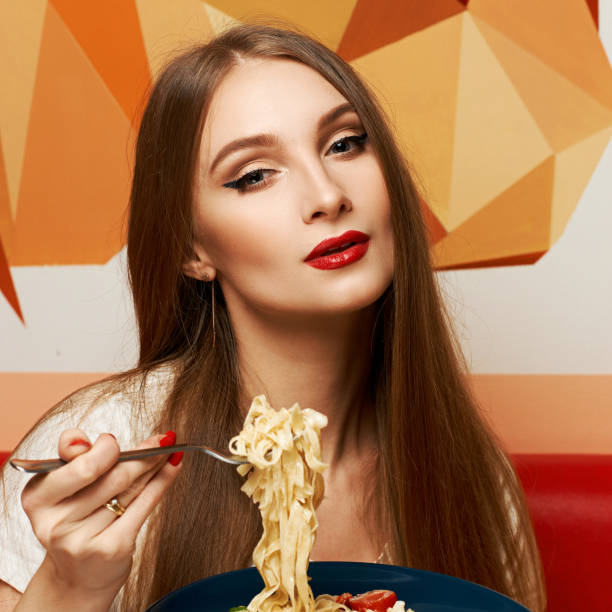 istock Attractive woman eating seafood pasta 974617948