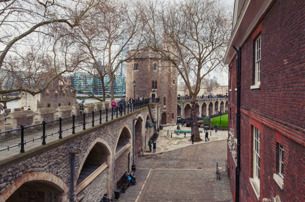 old buildings and towers in the inner ward area of royal palace and fortress of the tower of london, a historic castle and popular tourist attraction located on the north bank of the river thames in central london, england - built structure church flint stone imagens e fotografias de stock