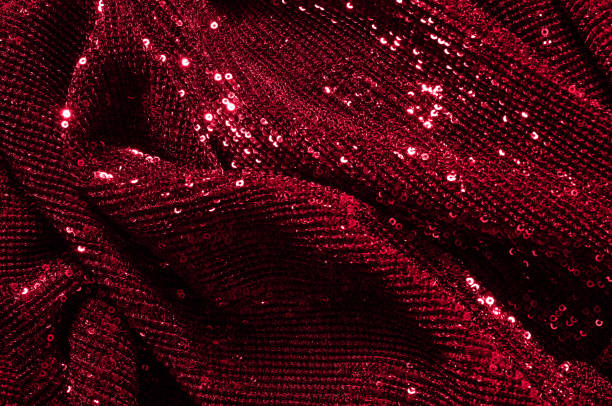 istock Texture, background, pattern, red fabric with paillettes. Look at these neon red sequins. Round neon pink sparkles glitter overlapping iridescent glitter on a clean purple grid. 974627552