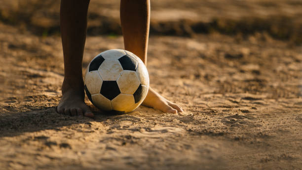 運動のために日没前にサッカーをプレーする子供のグループのアクション スポーツ写真。 - soccer field dirty soccer outdoors ストックフォトと画像