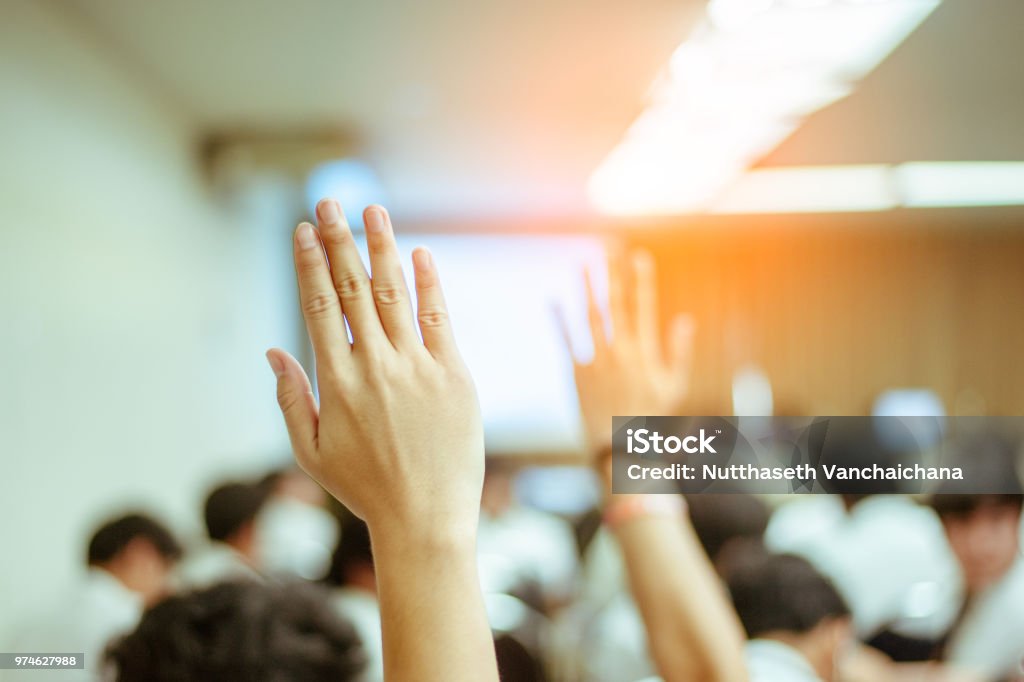 businessman raising hand during seminar. Businessman Raising Hand Up at a Conference to answer a question. Citizenship Stock Photo