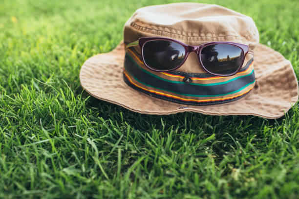 hat of a traveler with sunglasses on the grass