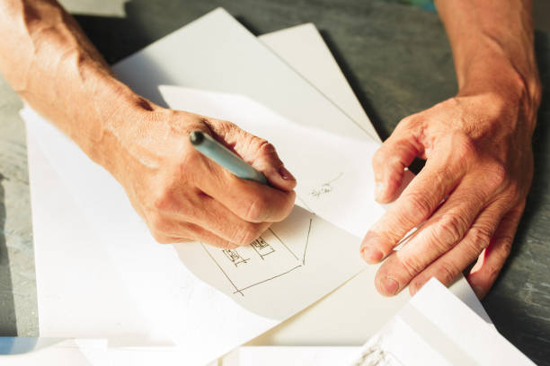 istock Close up man working of Architect sketching a construction project on his plane project at site construction work 974637220