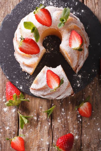 istock Sliced pound cake with fresh mint and strawberries close-up. Vertical top view 974637624