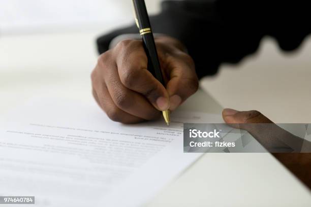 Close Up Of Black Worker Signing Legal Documentation Stock Photo - Download Image Now