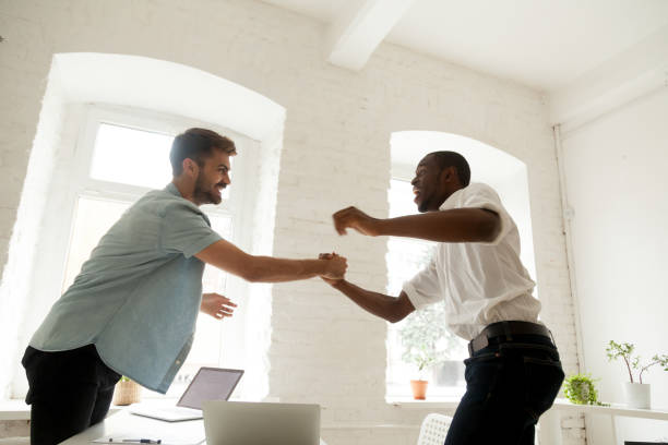istock Excited office workers handshaking celebrating business success 974640880