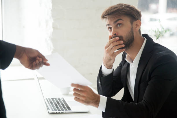 istock Shocked worker getting dismissal notice from black boss 974640962