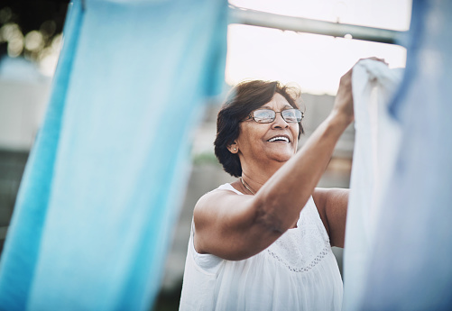 Shot of a mature woman hanging up laundry on a washing line outdoors