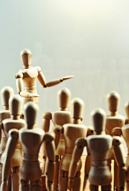 istock Wooden lay figure or puppet addresses crowd 974647388