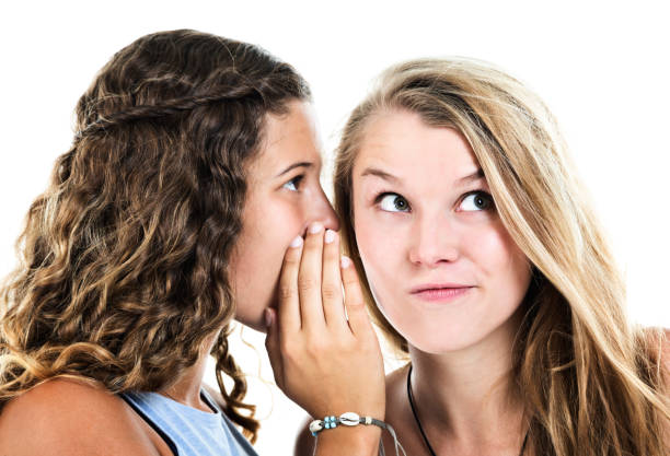istock Two beautiful girlfriends whispering scandalous secrets 974650614
