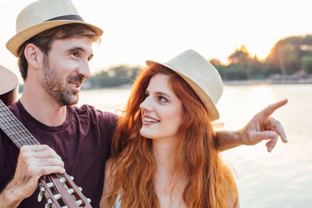 istock Young couple with a guitar by the river 974651064