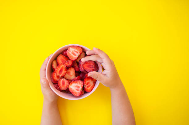 istock Strawberry in a bowl on yellow background. 974653624