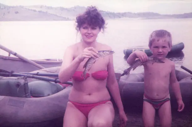 Photo of Mother and her son fishing pikes on lake.