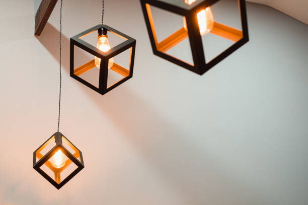 istock Group of modern luxury light lamp, edison lamp square box shape hanging down from ceiling in gray color room with copy space. 974657364