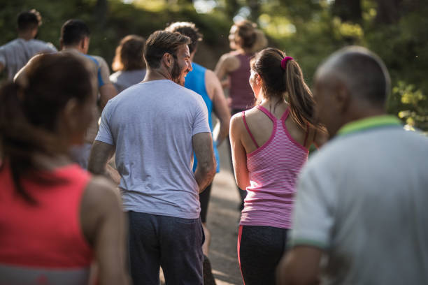 istock Back view of happy runners talking while having a marathon race through nature. 974660898