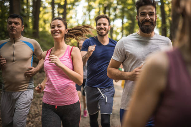 istock Group of happy athletes running a marathon through the forest. 974663300