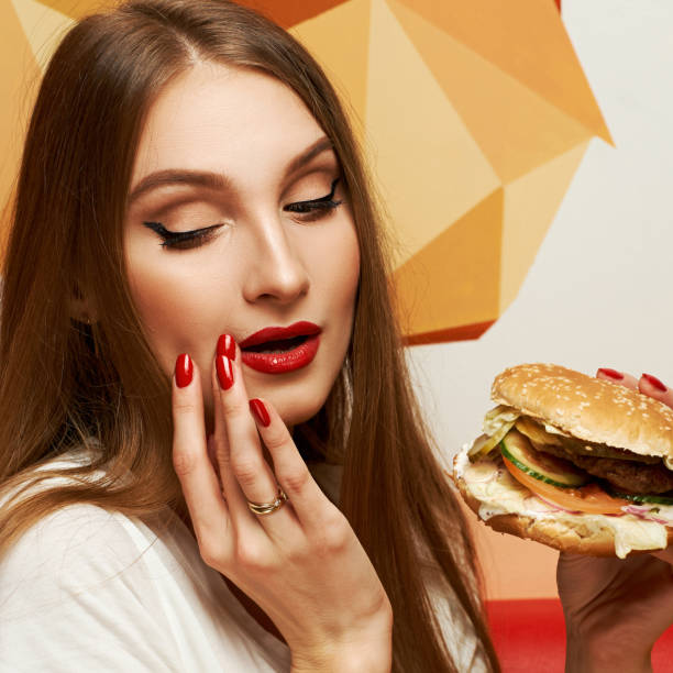 istock Playful girl posing with burger 974663484