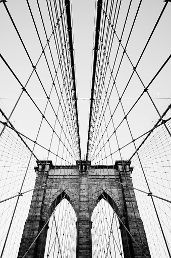 Brooklyn Bridge cables and suspension ties with one of the brick support towers and the climb prevention devices.