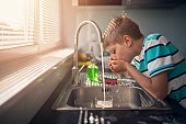 Little boy drinking tap water