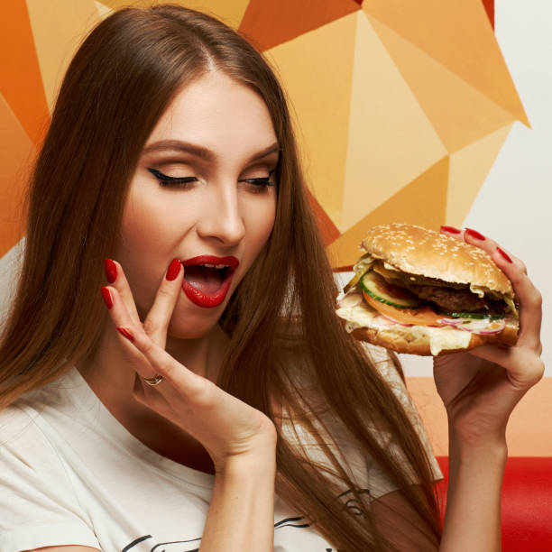 istock Playful girl posing with burger 974664202
