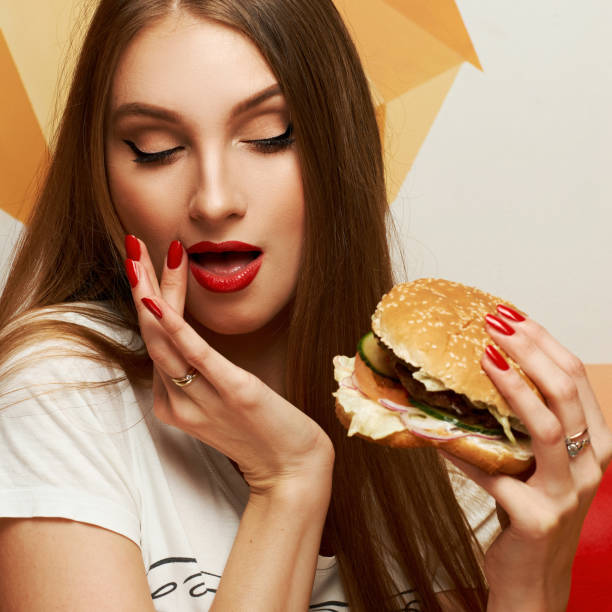 istock Playful girl posing with burger 974664628