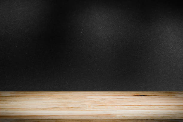 istock empty wooden on black backdrop with spotlight. Wood table top. can used for display or montage your products 974666822