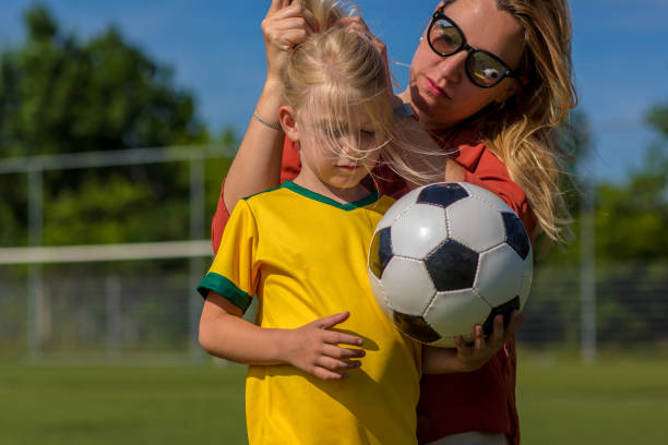 istock Soccer Mom preparing her blond daughter for football training 974671928