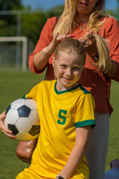 istock Soccer Mom preparing her blond daughter for football training 974672020