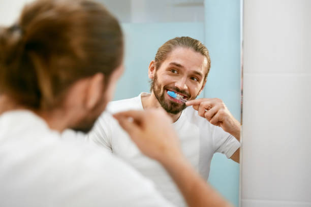 istock Man Brushing Teeth. Male Cleaning Teeth In Bathroom. 974680588