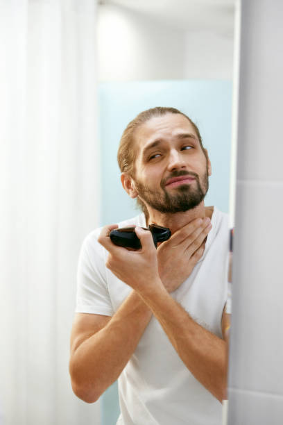 istock Man Shaving Face, Looking In Mirror. 974680646