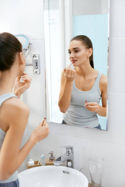 istock Woman Doing Makeup In Bathroom In Morning. 974683120