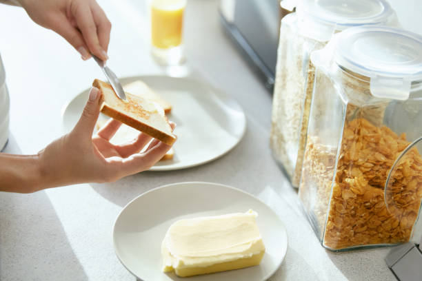 istock Woman Hands Applying Butter On Bread. 974683236