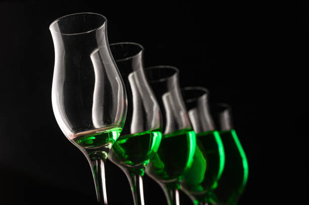 Glasses of green drink, beverage on black background