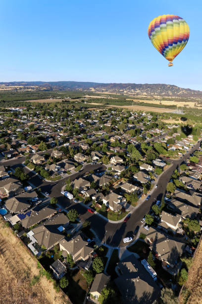 istock Hot -air balloon over a peaceful town 974687252