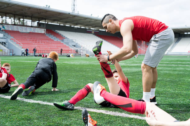 istock Junior Football Team Stretching at Practice 974687970