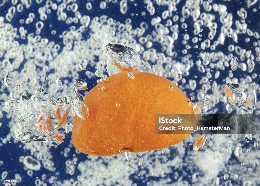 Orange (mandarin) flottant dans l'eau avec des bulles d'air - Photo de Agrume libre de droits