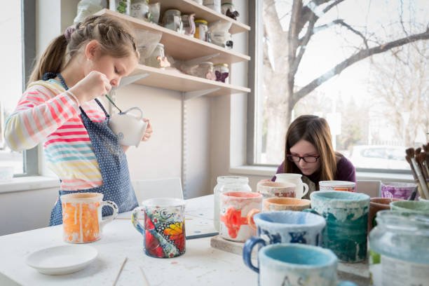 istock Girls painting pottery 974691008