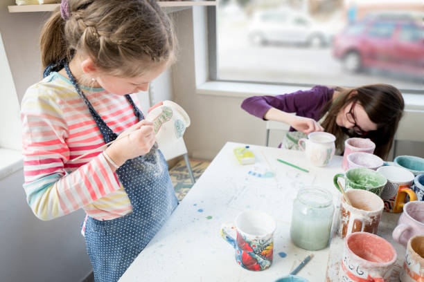 istock Two girls decoration pottery cups 974691112