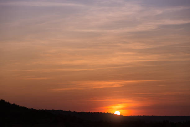 istock orange sunset, the sun sets behind the coastline, a large sky space, beautiful fluffy clouds, a summer evening landscape, the concept 974694510