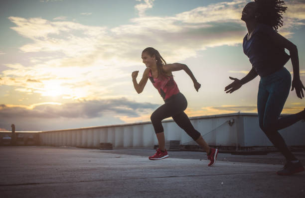 istock Two Female Athletes Exercising, Running Outdoors 974695456