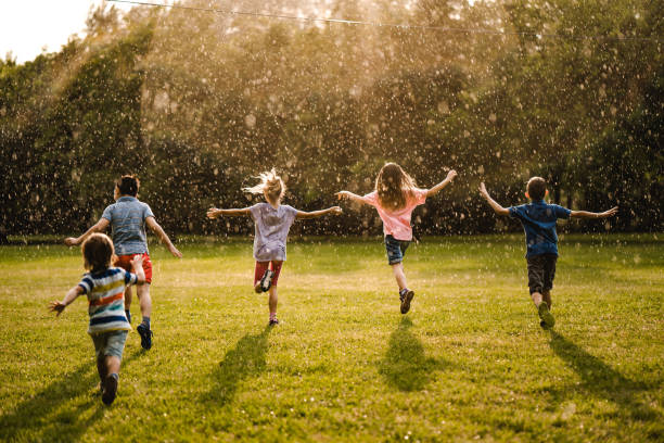 istock Back view kids enjoying on the rain 974706300